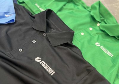 Black and green polo shirts with an embroidered white company logo on the chest by 400 Ink